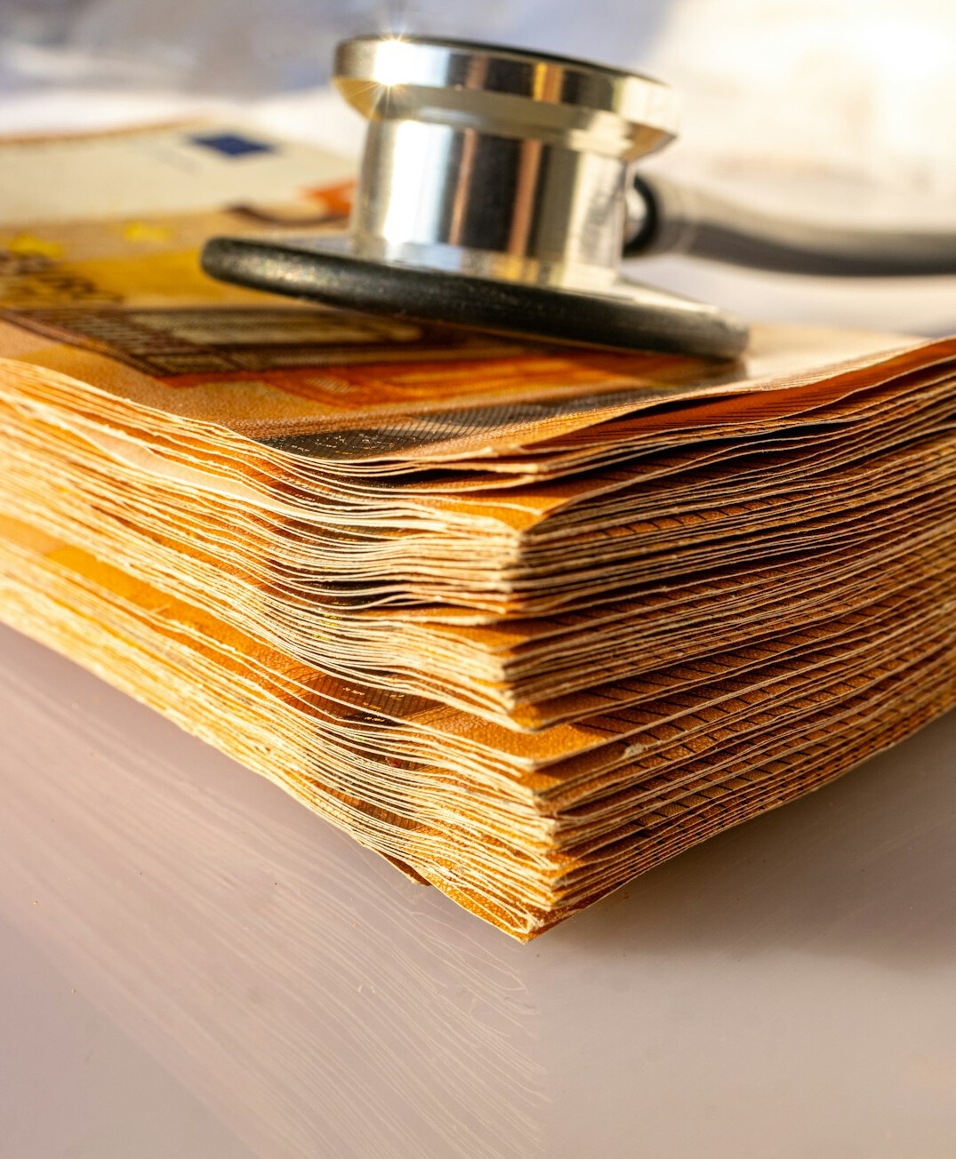 Stack of medical insurance paperwork and a stethoscope on a desk